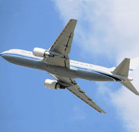 a photo of a blue and white airplane flying into a blue sky