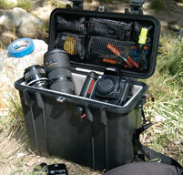 green peli case open showing camera equipment inside.